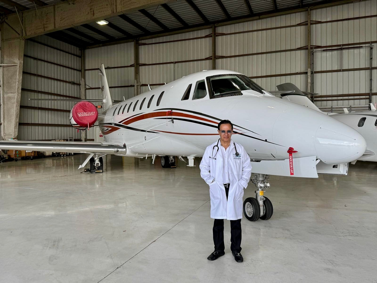 Dr. Phanor Calle standing in front of a private jet, FAA Aviation Medical Examiner for pilots