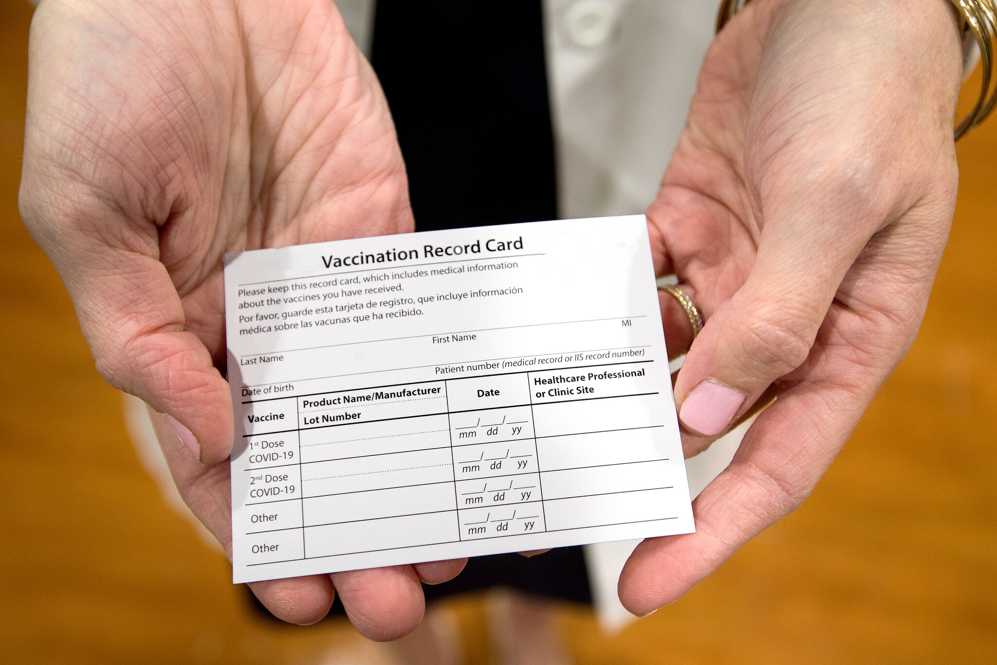 Person holding a vaccination record card